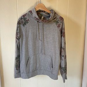 Cowl neck top with floral accents.